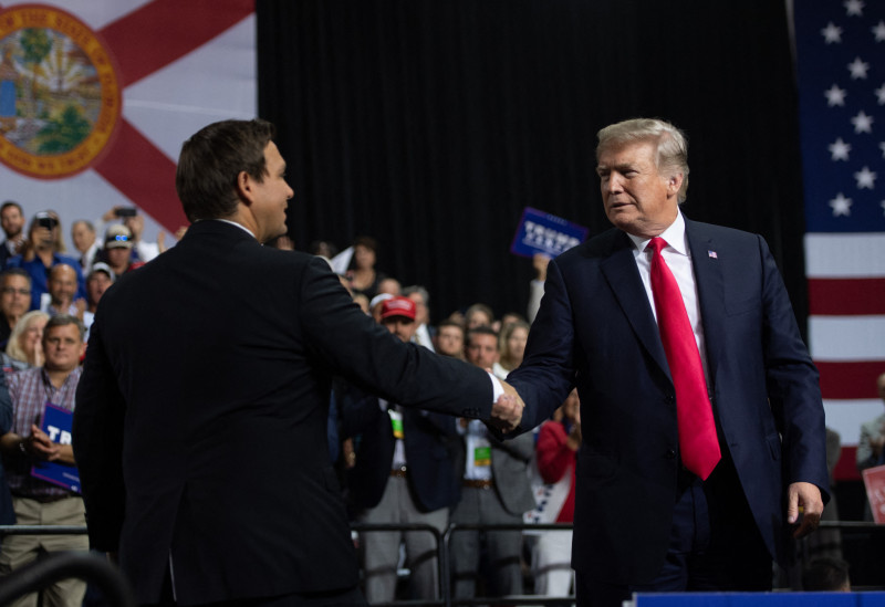 El gobernador de Florida, Ron DeSantis, y el expresidente Donald Trump se saludan durante un mitin en julio de 2018.