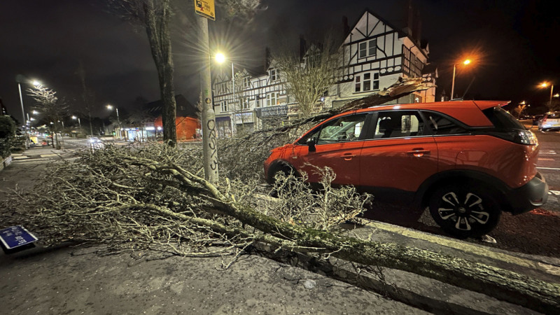 Una rama caída se ve sobre un auto en la calle Lisburn de Belfast, en el Irlanda del Norte, al paso de la tormenta Isha el domingo 21 de junio de 2024.