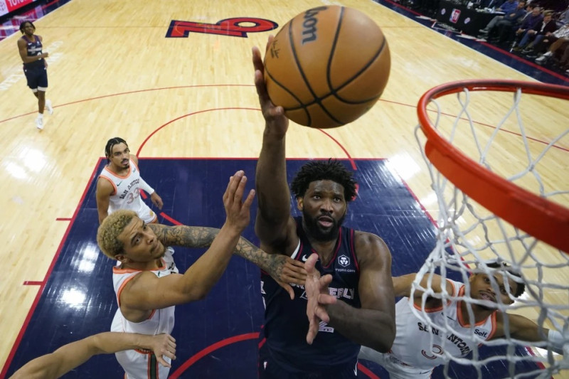 Joel Embiid, Filadelfia, toma un disparo entre Jeremy Sochan, izquierda, y Keldon Johnson, de los Spurs, durante la segunda mitad del juego de baloncesto de la NBA.