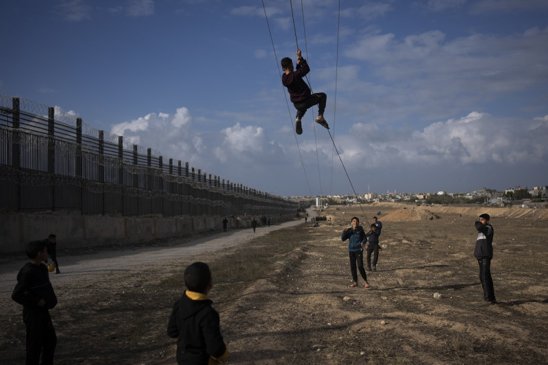 Palestinos desplazados del norte de la Franja de Gaza por los bombardeos israelíes juegan cerca de la frontera con Egipto, el domingo 14 de enero de 2024, en Rafah.