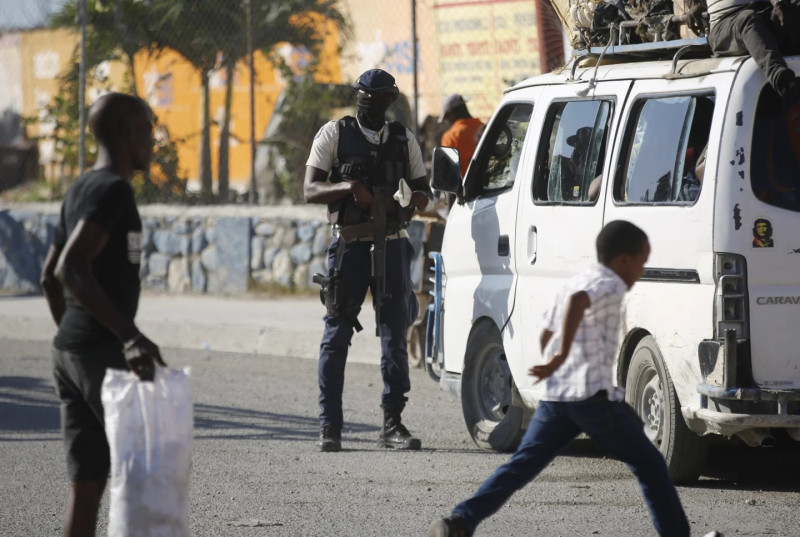 Oficial de policía inspecciona un vehículo de transporte en Haití