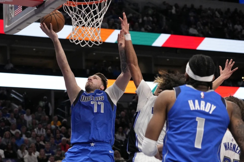 Luka Doncic, de Dallas, supera la marca defensiva de Anthony Black, del Magic de Orlando, para encestar durante la primera mitad del juego de baloncesto de la NBA.