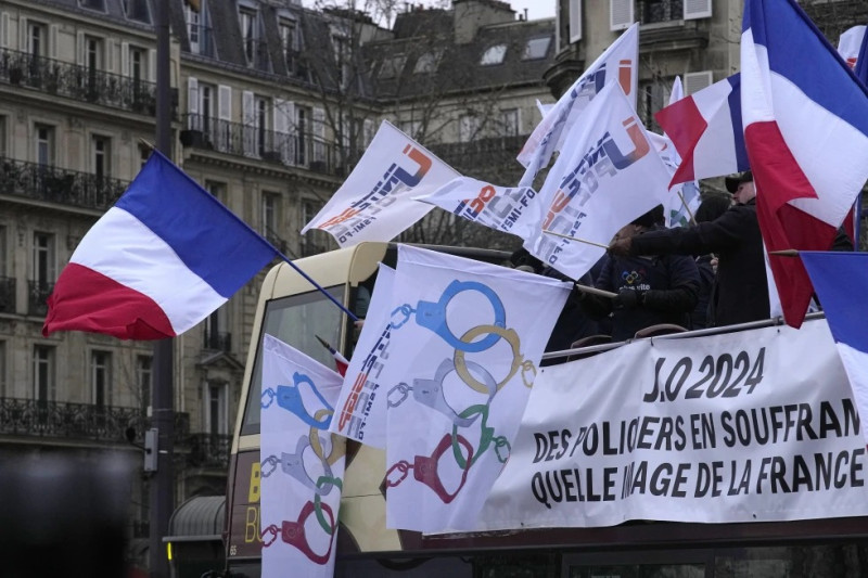 Policías de París se manifiestan con banderas que convierten los anillos olímpicos en esposas, el 10 de enero de 2024.