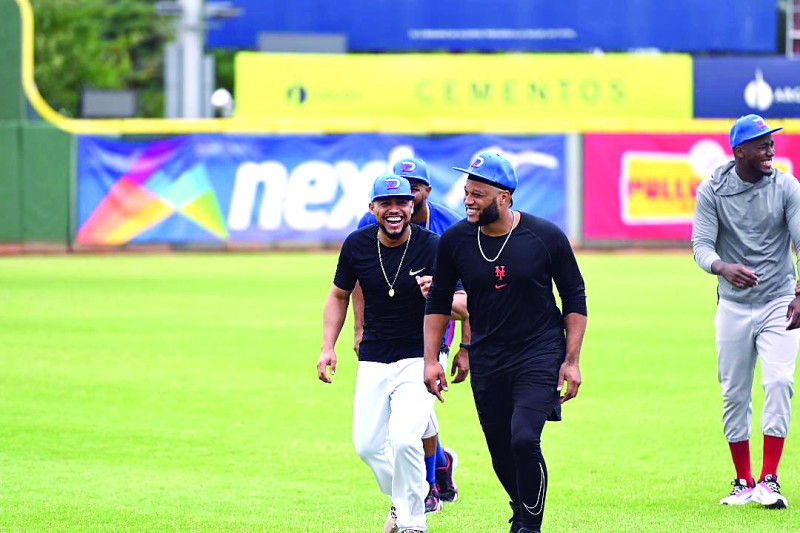 Robinson Canó sonríe con sus compañeros Gustavo Núñez y Junior Lake durante la práctica del equipo dominicano que parte hoy a Miami para la Serie del Caribe.