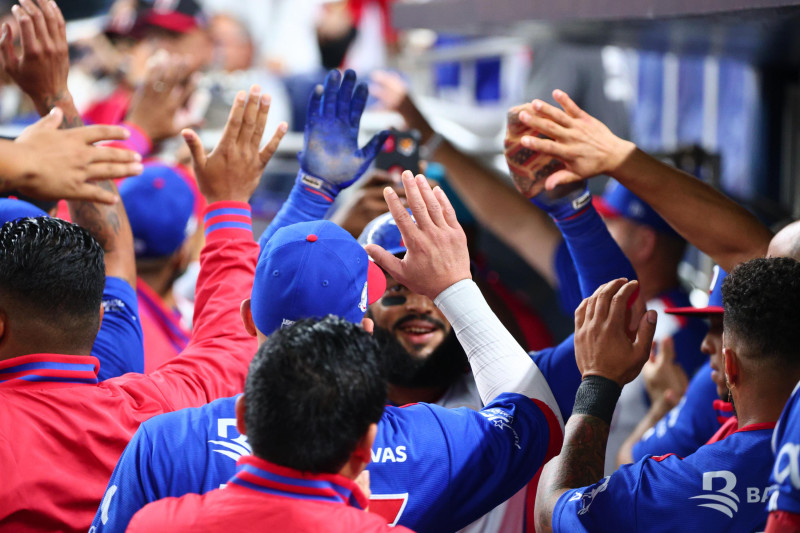 Jugadores dominicanos celebran al anotar una carrera ante México en la Serie del Caribe que se celebra en Miami