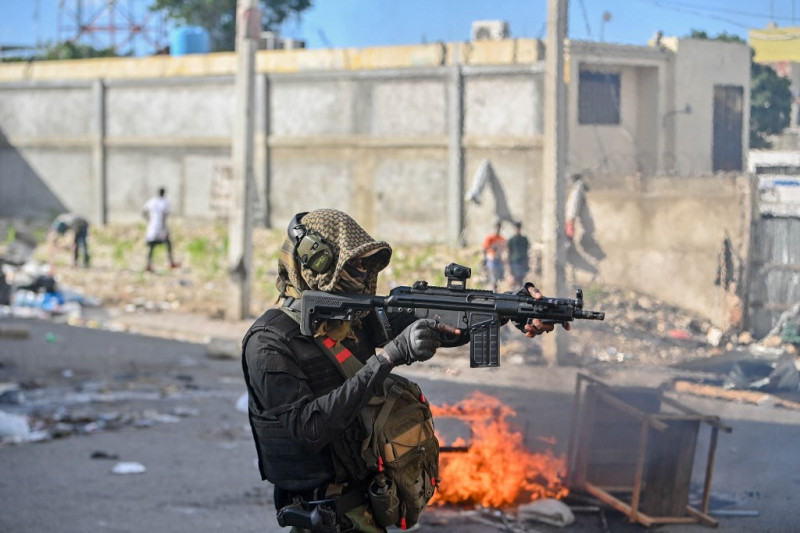 Un policía apunta con un arma a los manifestantes durante una manifestación pidiendo la dimisión del primer ministro Ariel Henry en Puerto Príncipe el 7 de febrero de 2024.