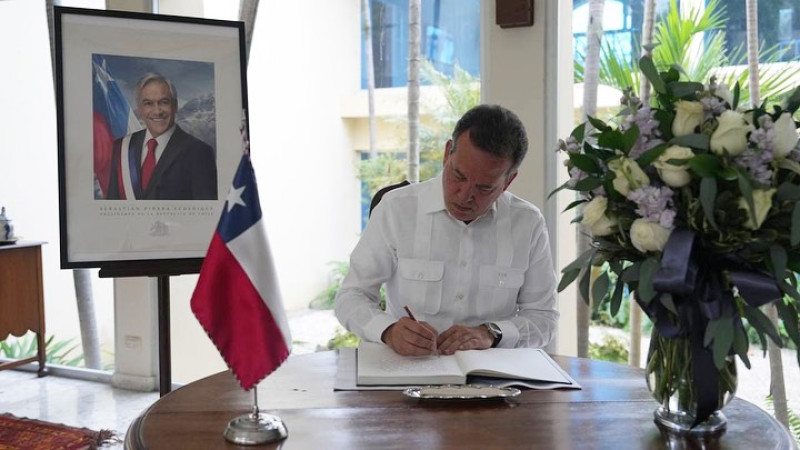 Instante en que el ministro de Industria y Comercio, Ito Bisonó, firma el libro de condolencias por el fallecimiento del expresidente de Chile, Sebastián Piñera.
