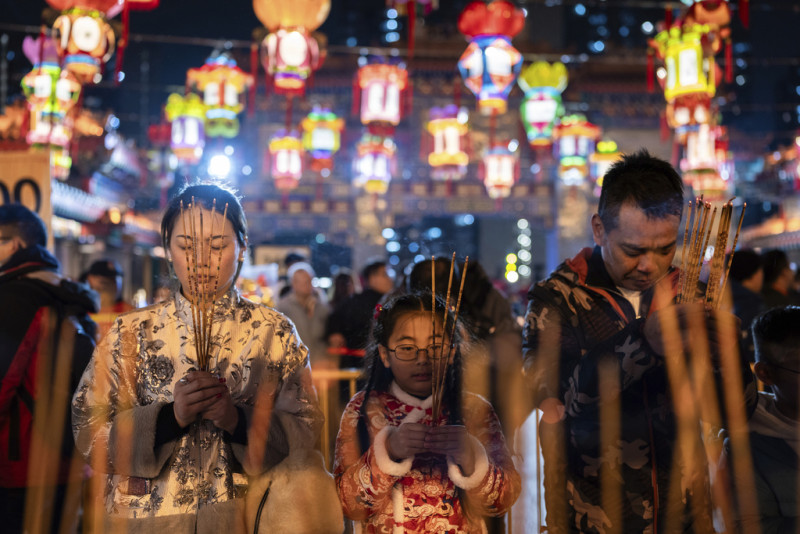 Fieles rezan mientras encienden varas de incienso en un templo para recibir el Año Nuevo Lunar, en Hong Kong, el 9 de febrero de 2024.