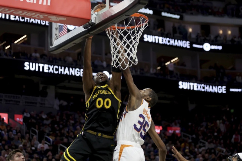 El alero de los Warriors, Jonathan Kuminga (00), dispara contra el alero de los Suns, Kevin Durant (35), durante la segunda mitad del partido de baloncesto de la NBA.