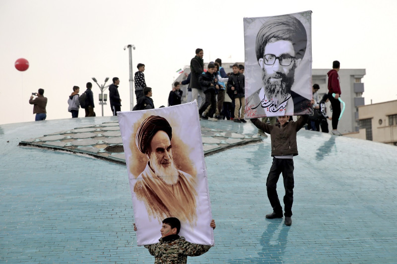 Dos niños sostienen carteles del líder supremo iraní, el ayatolá Ali Jamenei, y el fallecido fundador de la revolución iraní el ayatolá Jomeini, a la izquierda, durante una marcha en Teherán, Irán, el 11 de febrero de 2019.