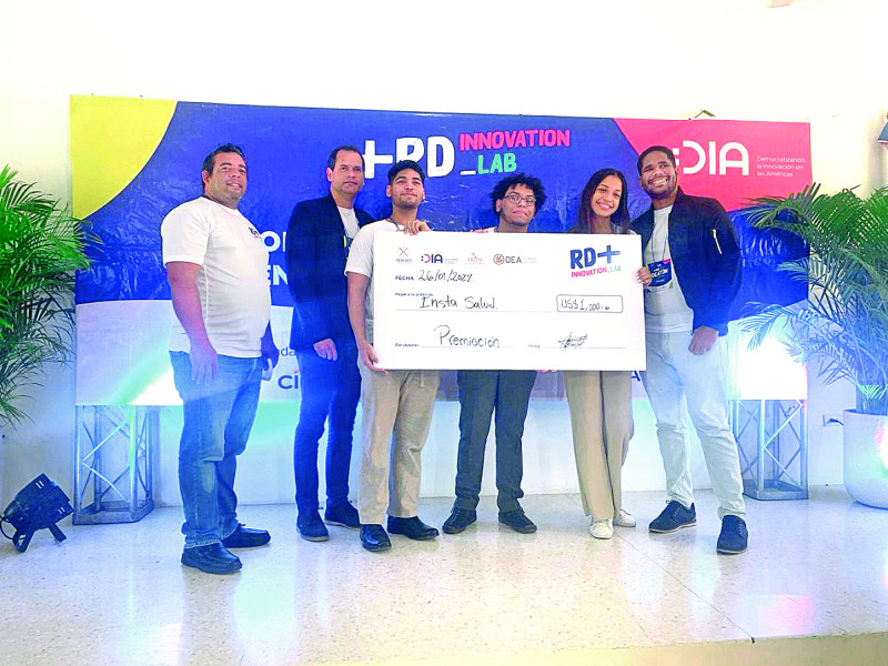 Estudiantes ganadores de la competencia de innovadores exhiben una muestra del premio de 1,000 dólares.