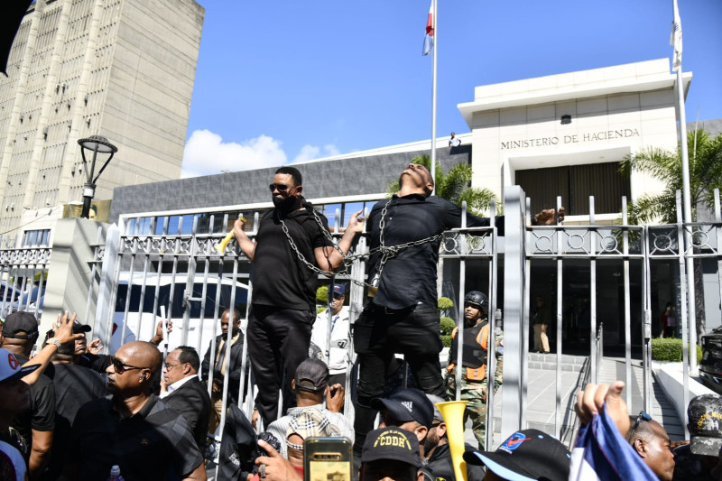 Dos de los manifestantes se encadenaron en la verja del Ministerio de Hacienda.