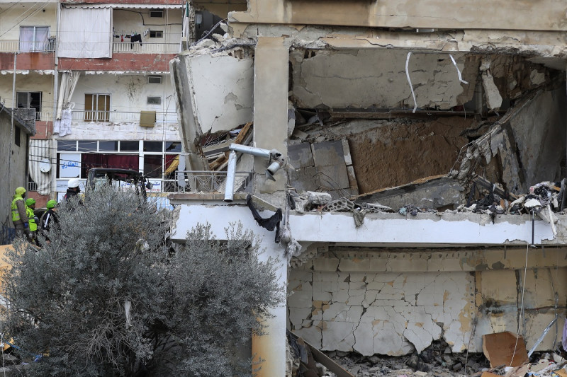 Rescatistas y operarios de defensa civil retiran los escombros de un edificio alcanzado en la víspera por un ataque aéreo israelí, en Nabatiyeh, ayer.