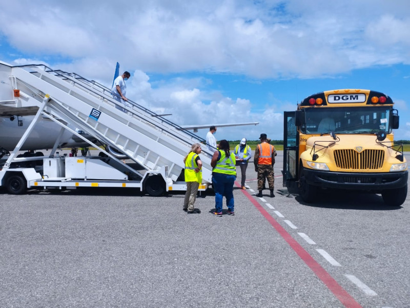 Dominicanos repatriados abordan vehículo que los llevará hasta Haina paradepuración.