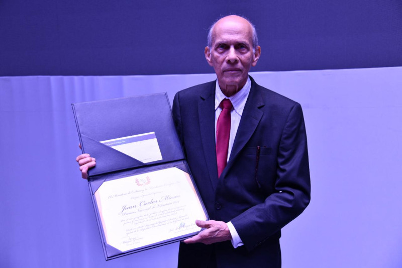 El escritor Juan Carlos Mieses posa con el certificado del premio entregado anoche.