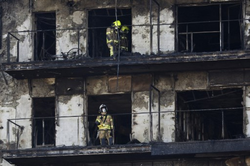 Los bomberos proceden a retirar el cuerpo de una víctima del enorme incendio que arrasó un bloque residencial de varias plantas matando al menos a diez personas, en Valencia el 23 de febrero de 2024.