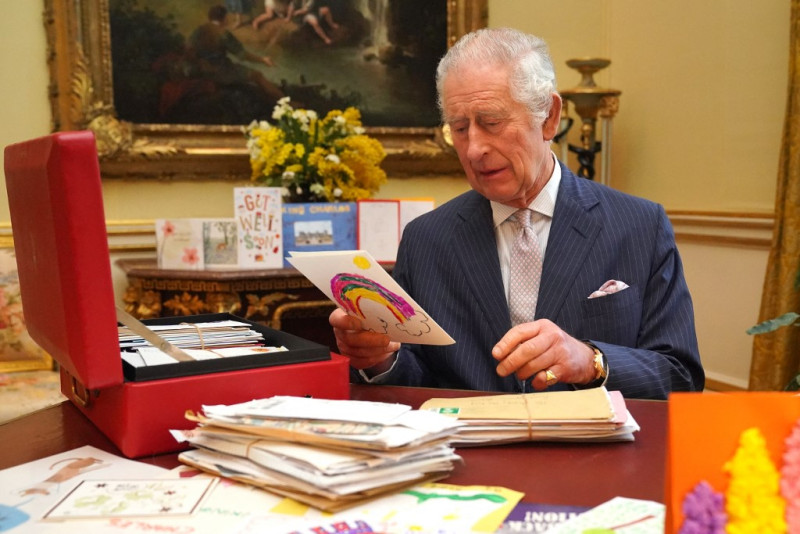 Carlos III posa para una fotografía mientras lee las tarjetas y mensajes enviados por sus allegados tras el diagnóstico de cáncer el 21 de febrero de 2024