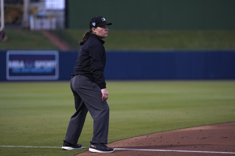 La umpire Jen Pawol toma su posición en la tercera base durante el juego de béisbol de entrenamiento de primavera entre Washington y Houston.