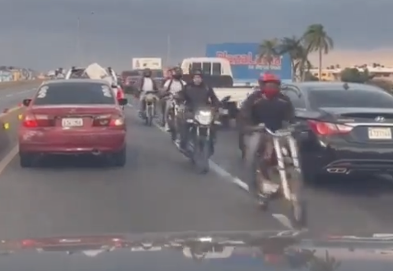 Un grupo de motociclistas circulan en vía contraria en una de las avenidas de la capital cruzando entre numerosos vehículos que vienen de frente.