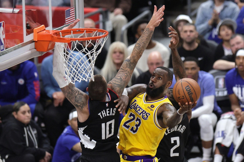 LeBron James, de los Lakers, se eleva en busca de un canasto ante la defensa de Daniel Theis, de los Clippers.