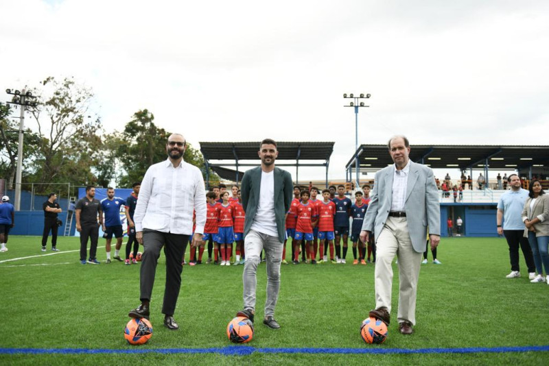 David Villa sostiene un balón de fútbol junto a Felipe Vicini, presidente Grupo INICIA y Francisco Elías Subadministrador del Banreservas.