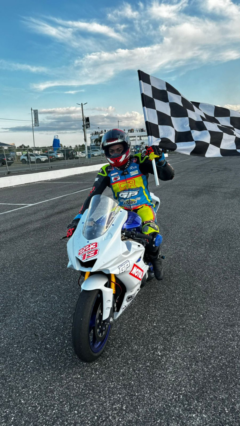 Persio López exhibe la bandera a cuadros que obtuvo en la principal categoría del Campeonato de Motovelocidad.