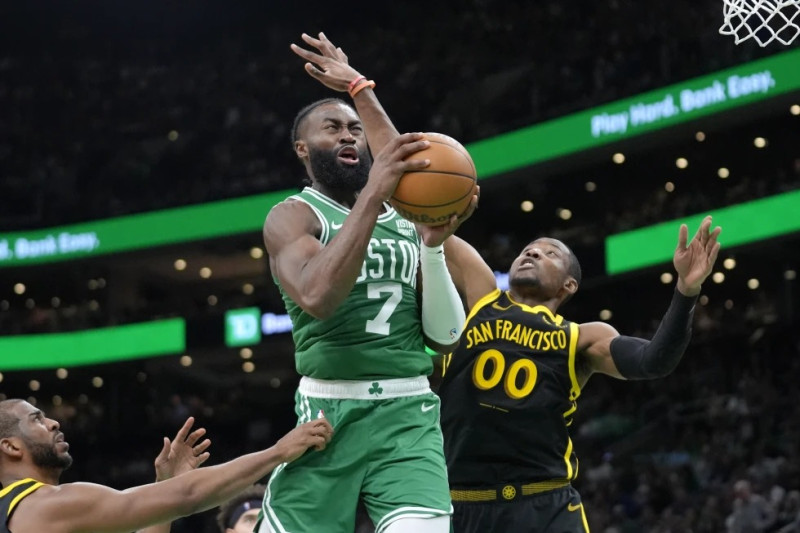 Jaylen Brown (7), de los Celtics de Boston, ataca la canasta mientas Jonathan Kuminga (00), de los Warriors de Golden State, hace labores defensiva.