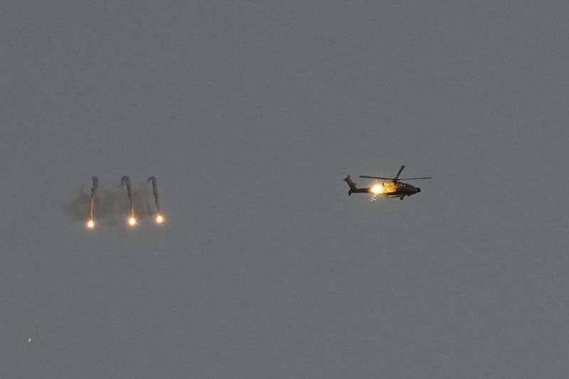 Un helicóptero Apache israelí, fotografiado desde el sur de Israel, dispara bengalas sobre la Franja de Gaza, lunes 4 de marzo de 2024.