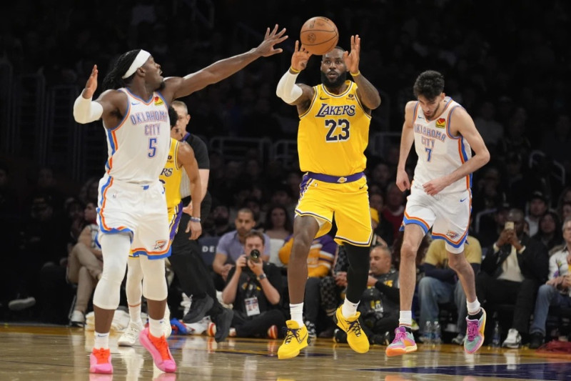 LeBron James (23), de los Lakers, pasa el balón sobre Luguentz Dort (5), del Thunder de Oklahoma City, durante la segunda mitad del juego de baloncesto de la NBA.