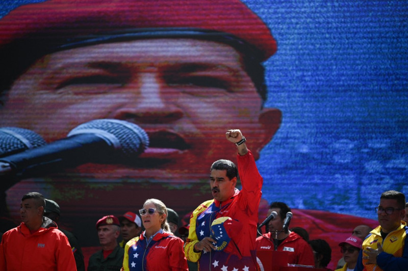 El presidente venezolano Nicolás Maduro y la primera dama, Cilia Flores, saludan a simpatizantes durante un mitin para conmemorar los 20 años de la declaración antiimperialista del fallecido Hugo Chávez, en Caracas, el 29 de febrero de 2024