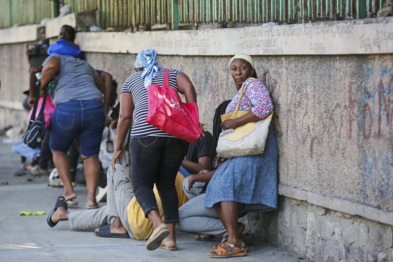 Los peatones se refugian durante los enfrentamientos entre la policía y pandilleros en Puerto Príncipe.