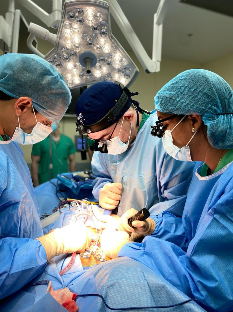 Médicos especialistas en cirugía y ortopedia participan en una operación a un paciente con escoliosis.z
