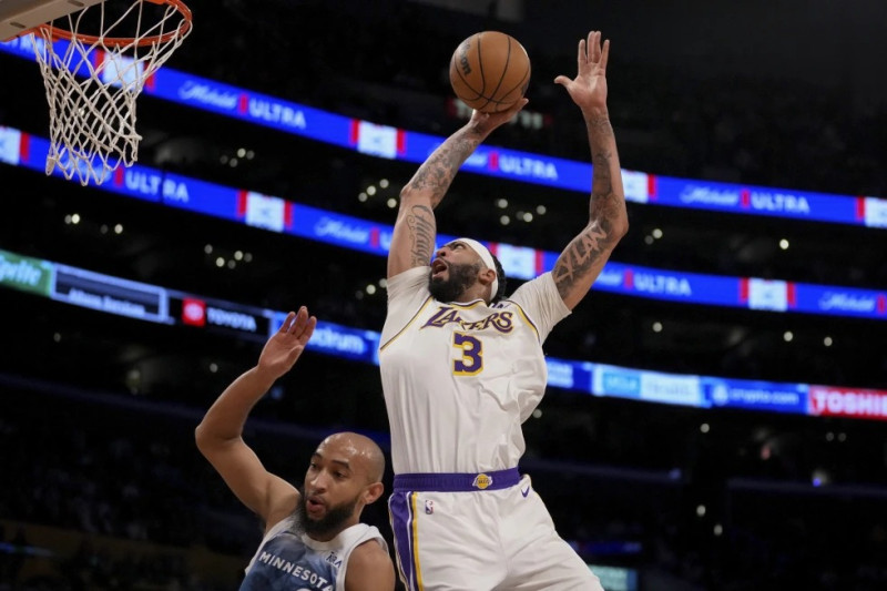 Anthony Davis (3), de los Lakers, se alza para anotar superando a Jordan McLaughlin, de los Timberwolves de Minnesota, durante la primera mitad del juego de la NBA.