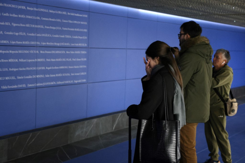 Una mujer reacciona ante los nombres de las víctimas de los atentados del 11-M, que acabaron con la vida de 192 personas el 11 de marzo de 2004, en un espacio conmemorativo de reflexión inaugurado la víspera en la estación de Atocha de Madrid el 11 de marzo de 2024.