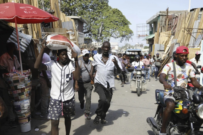 Los peatones corren a refugiarse después de escuchar disparos en Puerto Príncipe, Haití