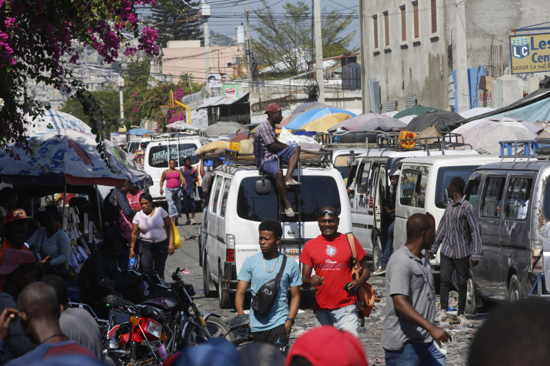 Vista de peatones y tráfico en una calle de Puerto Príncipe, Haití, 12 de marzo de 2024. Una propuesta para instalar un gobierno provisional en Haití parecía colapsar el miércoles 13 de marzo de 2024 cuando algunos partidos políticos rechazaron el plan de crear un consejo presidencial para administrar la transición.(AP Foto/Odelyn Joseph)