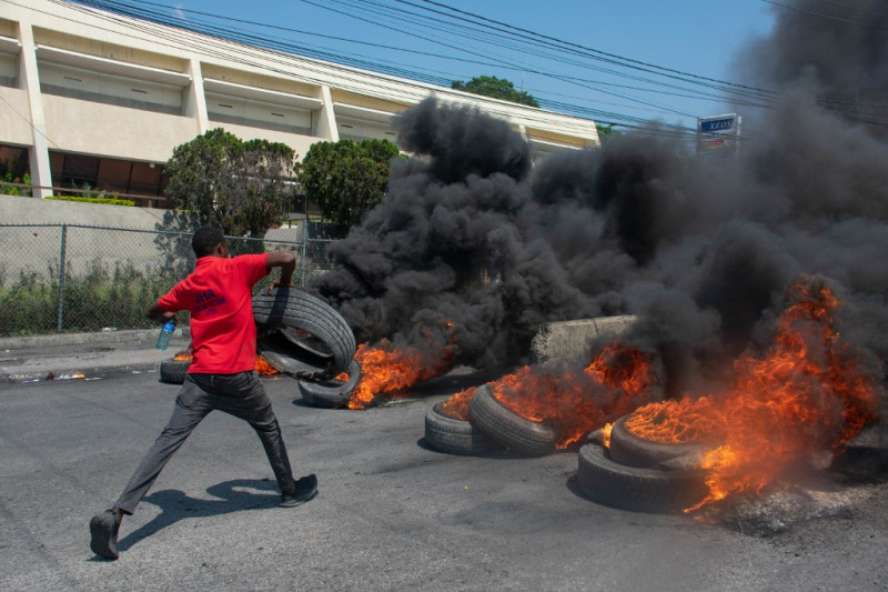 Un manifestante quema neumáticos durante una manifestación tras la dimisión de su Primer Ministro Ariel Henry, en Puerto Príncipe, Haití, el 12 de marzo de 2024.