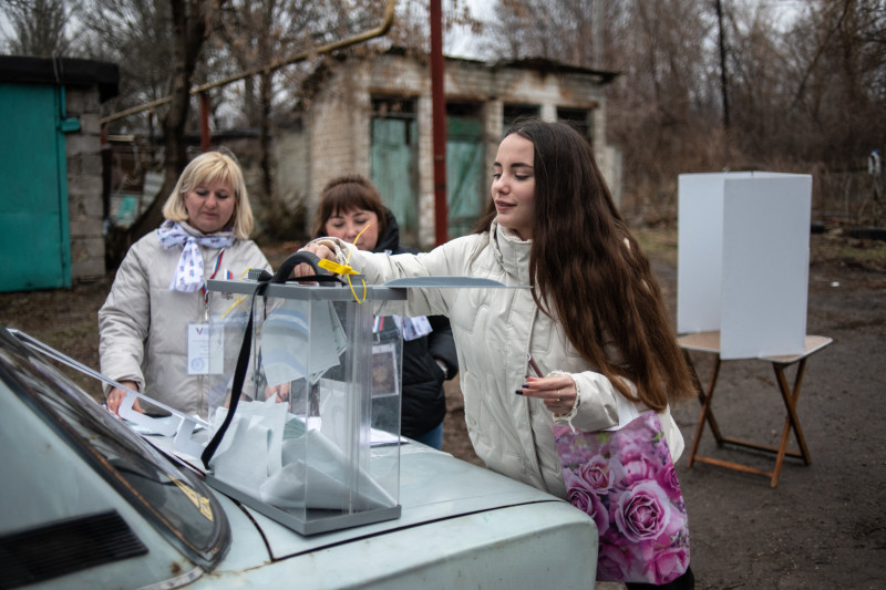 Una mujer emite su voto en un colegio electoral móvil durante la votación anticipada de las elecciones presidenciales de Rusia en Donetsk, Ucrania controlada por Rusia,