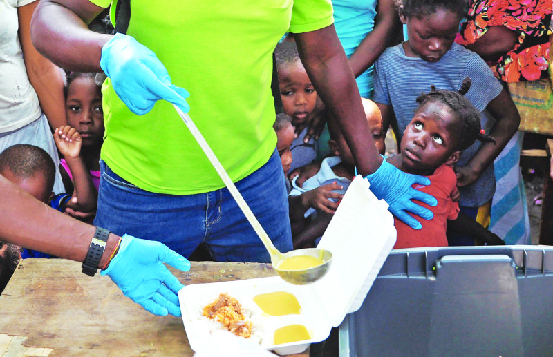 Agencias humanitarias distribuían comida ayer a personas desplazadas por la violencia que sacude la capital haitiana.