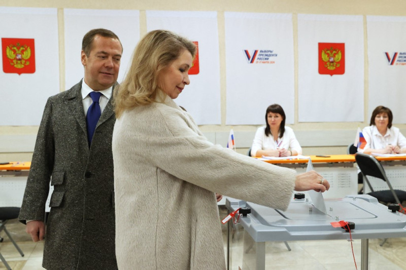 En esta fotografía colectiva distribuida por la agencia estatal rusa Sputnik, Dmitry Medvedev, el ex presidente de Rusia que ahora se desempeña como vicepresidente del Consejo de Seguridad del país, y su esposa Svetlana votan en las elecciones presidenciales de Rusia en la región de Moscú el 15 de marzo de 2024.