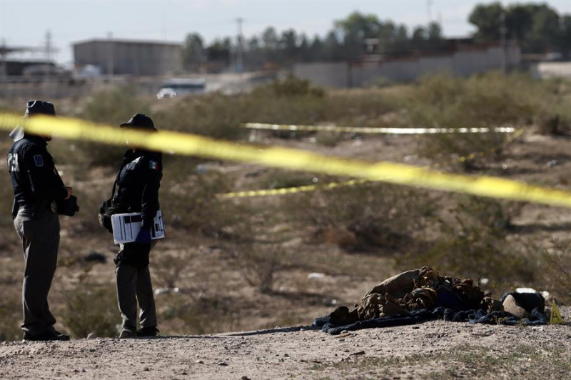 Personal de la policía municipal resguardan la zona donde se localizó una fosa clandestina con seis cuerpos, este jueves en Ciudad Juárez (México).