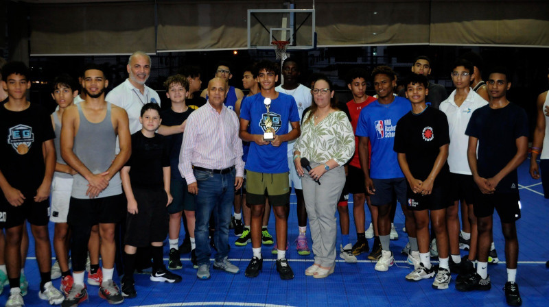 a vicepresidenta del Club Naco, Madelaine Andino, premia a los mejores en la disciplina de baloncesto.