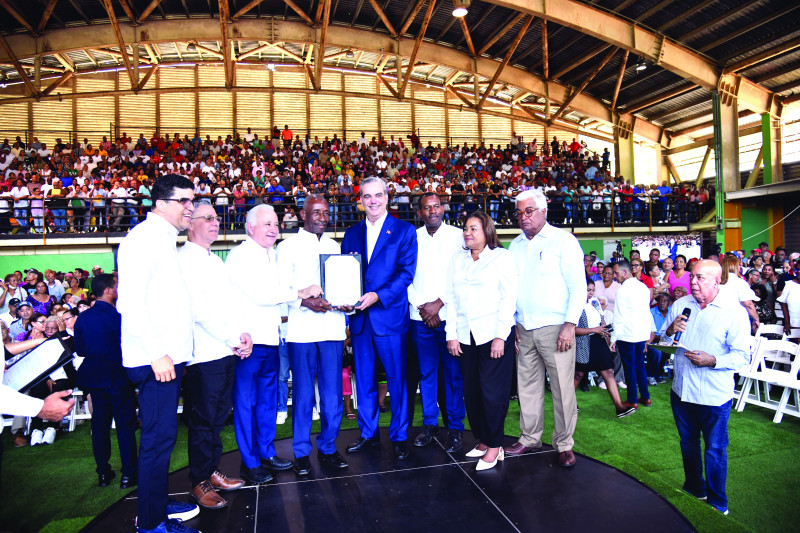 El presidente Luis Abinader entrega su título a un beneficiario.