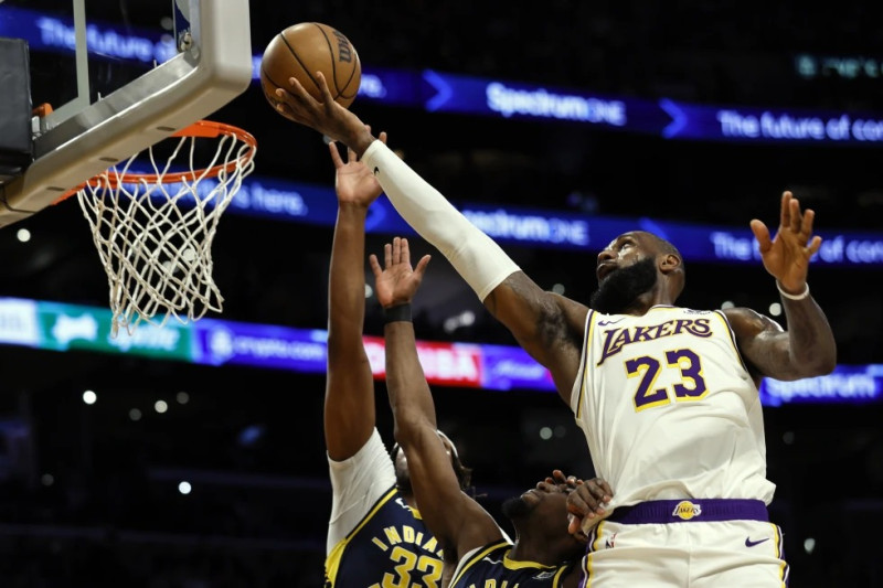 El alero de los Lakers de Los Ángeles LeBron James lanza el balón sobre el pívot de los Pacers de Indiana Myles Turner y el alero Aaron Nesmith.