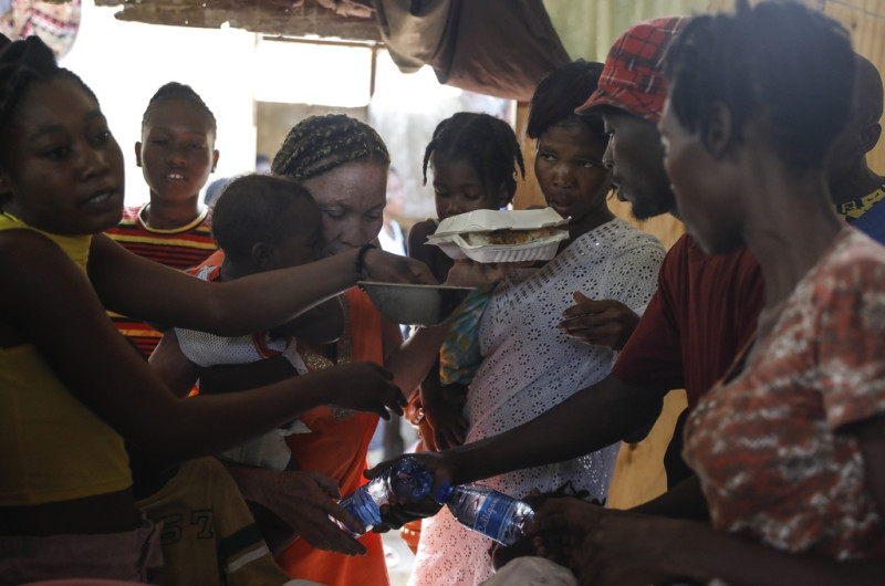 Mujeres pelean por platos de comida para sus hijos en un refugio para familias desplazadas por la violencia de las pandillas, en Puerto Príncipe, Haití, el viernes 22 de marzo de 2024.
