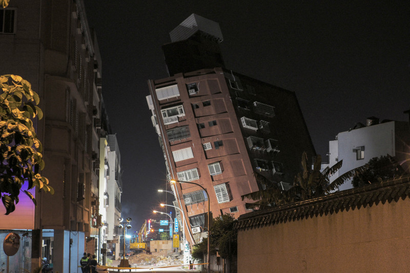 El personal de emergencia (primer plano) se encuentra frente a un edificio parcialmente derrumbado que se inclina sobre una calle en Hualien el 3 de abril de 2024, después de que un gran terremoto azotara el este de Taiwán.