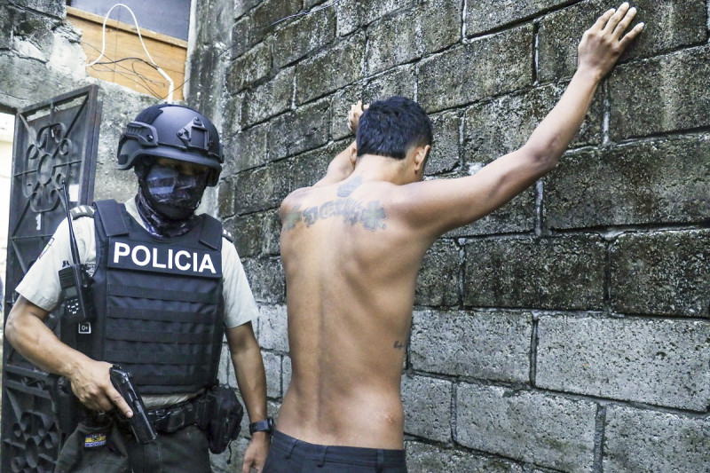 Un hombre levanta los brazos contra la pared mientras la policía revisa si lleva armas o drogas, en Guayaquil, ayer.