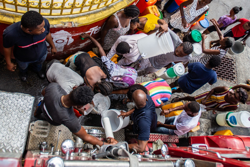 PUERTO PRÍNCIPE (HAITÍ), 07/04/2024.- Bomberos reparten agua potable en un campamento de refugiados este domingo en Puerto Príncipe (Haití). La violencia parece dar un respiro este fin de semana a los haitianos, que aprovechan la aparente calma para abastecerse e intentar recuperar en lo posible su 'normalidad'. EFE/ Mentor David Lorens