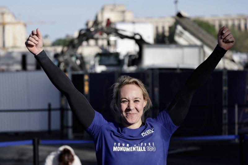 La atleta francesa Anouk Garnier celebra batir el récord mundial de escalada con cuerda después de subir con cuerda al segundo piso de la Torre Eiffel, en la Torre Eiffel de París, el 10 de abril de 2024.