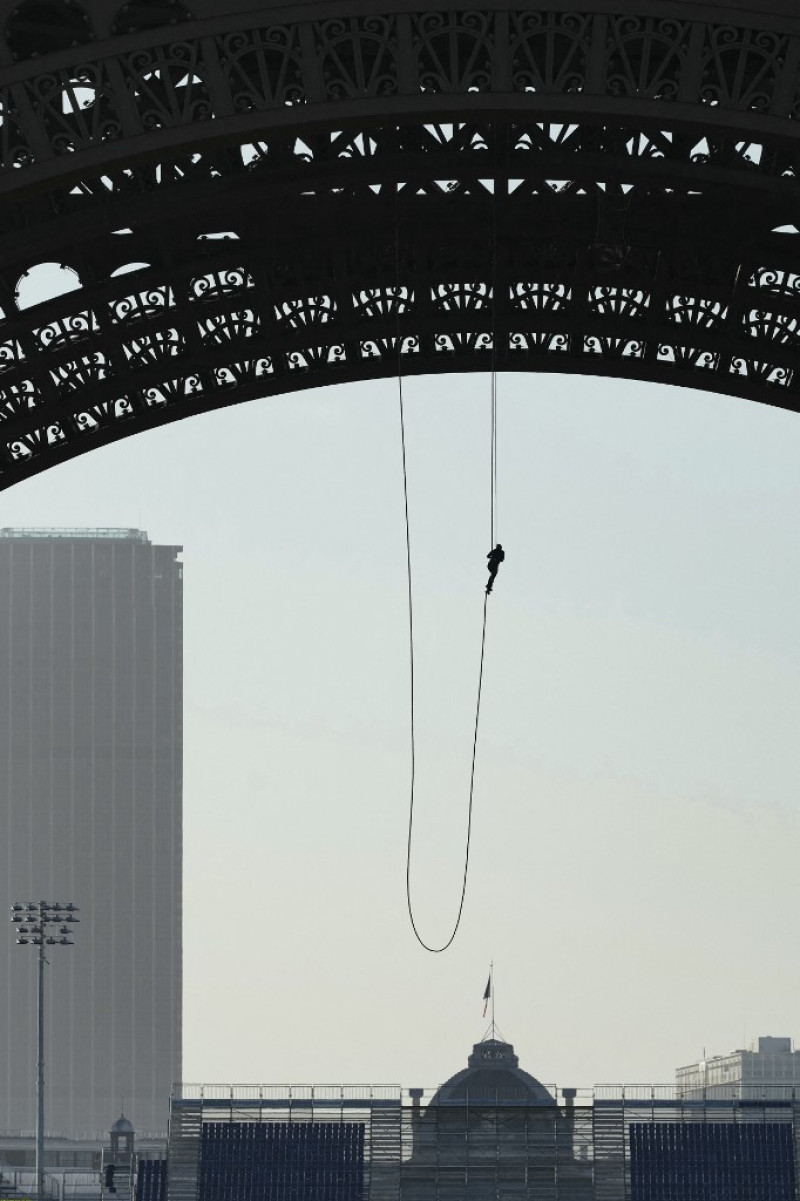 El atleta francés Anouk Garnier sube con cuerdas a la Torre Eiffel en un intento por batir el récord mundial, en la Torre Eiffel, mientras el Tour Montparnasse domina el horizonte (parte trasera izquierda) y la Ecole Militaire se perfila (centro, abajo) en París, en 10 de abril de 2024.
